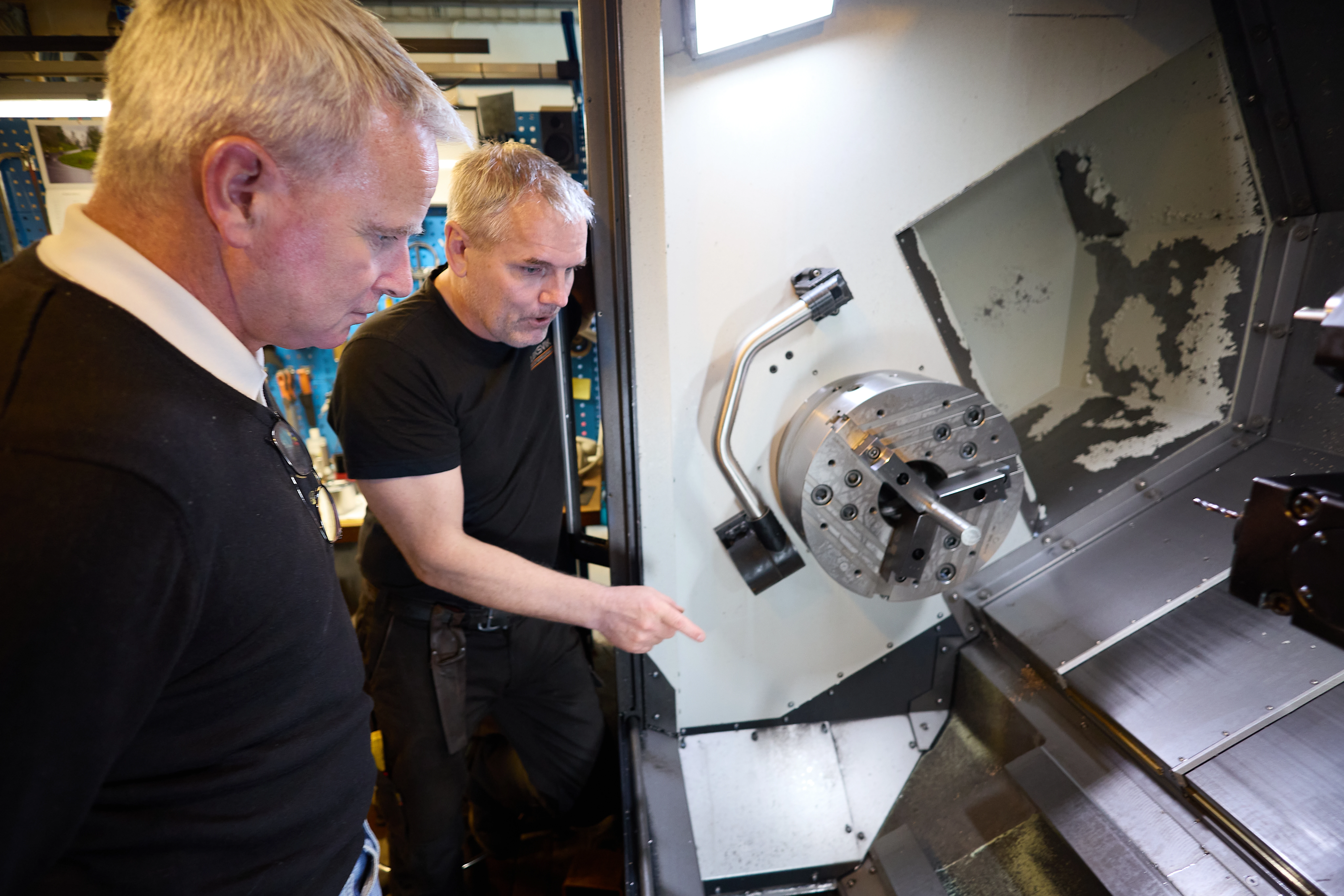 To menn som ser inn i en maskin